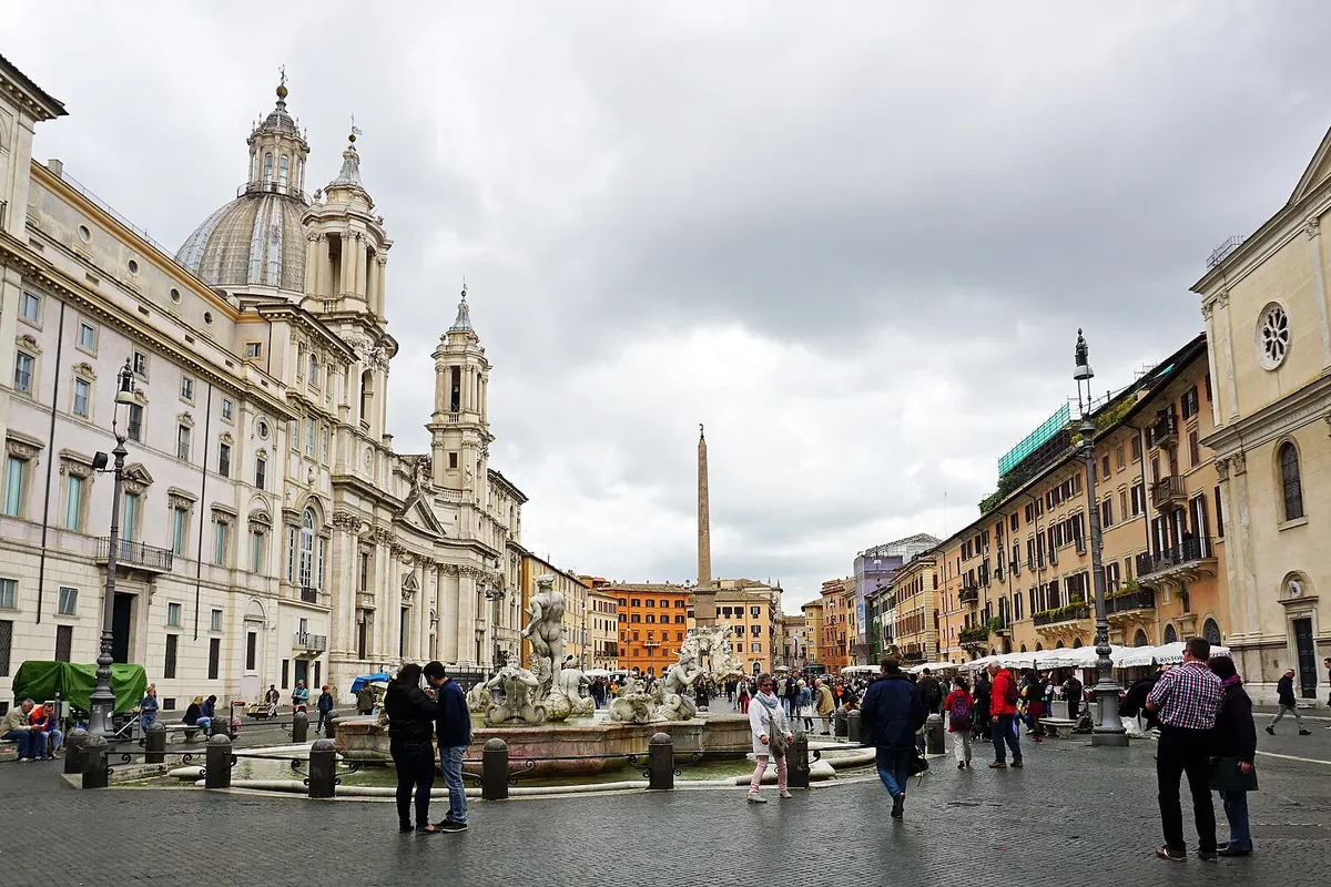 Piazza Navona on a grey day, with the Fountain of the Moor in the foreground, the obelisk beyond and Sant'Agnese in Agone on the left.